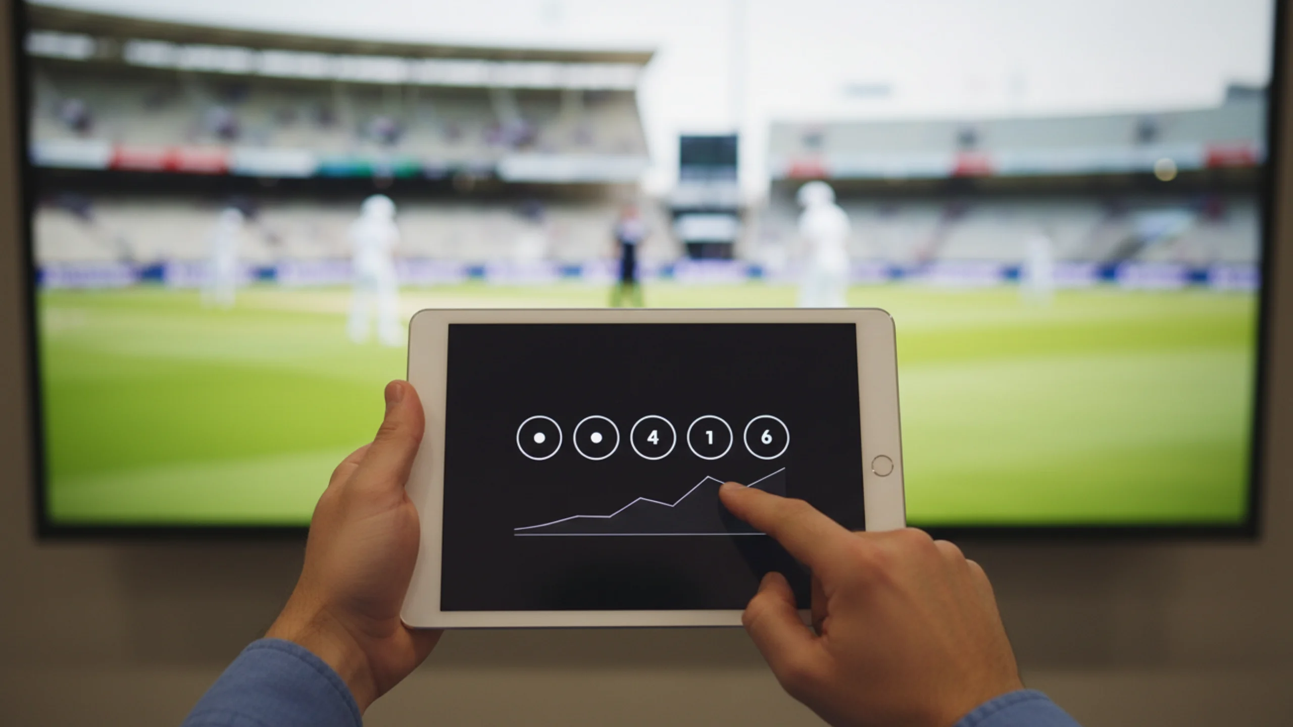 Cricket analyst studying detailed delivery-by-delivery statistics on tablet during live match